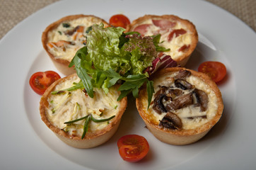 julienne in tartlet with salad and tomatoes on a white plate