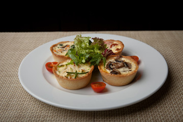 julienne in tartlet with salad and tomatoes on a white plate