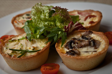 julienne in tartlet with salad and tomatoes on a white plate