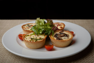 julienne in tartlet with salad and tomatoes on a white plate