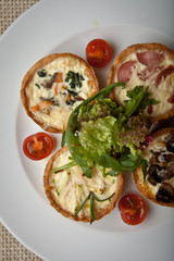 julienne in tartlet with salad and tomatoes on a white plate