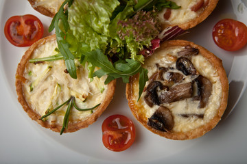 julienne in tartlet with salad and tomatoes on a white plate