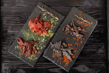 Assorted jerky on two served stone boards