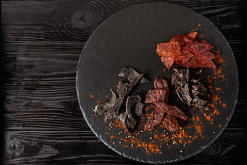 Spiced jerky on circle stone board