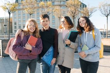 Outdoor portrait of a female teacher and group of teenage students, golden hour