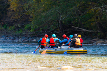 Group of young people make a rafting on mountain river