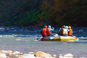 Group of young people make a rafting on mountain river