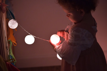 Small girl with Christmas tree lights