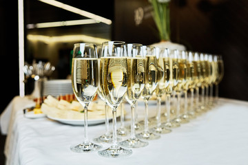 rows of champagne and sparkling wine glasses at banquet night time party new year corporate party concept
