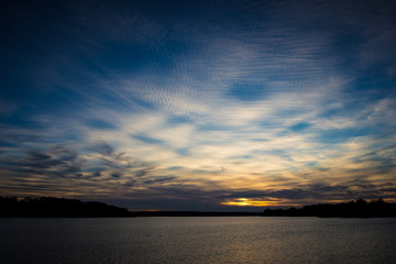 Curly clouds in rays of sun in the evening