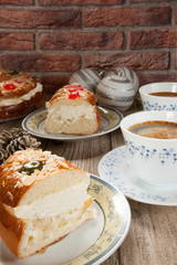 Two cut pieces of Spanish typical dessert of epiphany close-up on wood and brick background