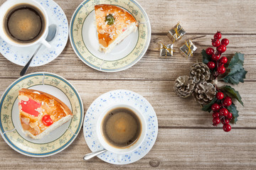 Fototapeta na wymiar Two cut pieces of Spanish typical dessert of epiphany with coffee and mistletoe