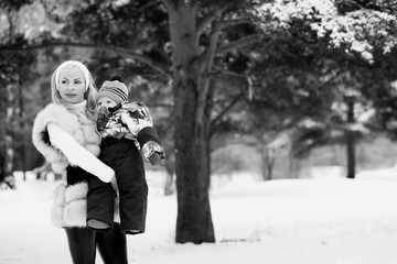 A young mother walks on a winter day with a baby in her arms