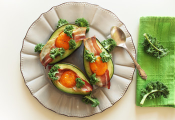 Breakfast. Avocado Egg Boats with crunchy bacon, kale cabbage on white background