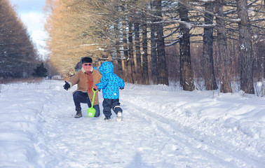 Kid playing in a winter park and have fun with family