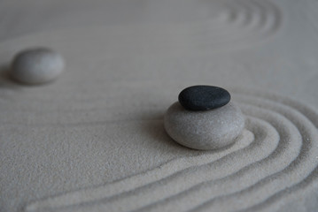Fototapeta premium Gray zen stones on the sand with wave drawings. Concept of harmony, balance and meditation, spa, massage, relax