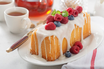 Butter vanilla cake for breakfast with glaze and fresh berries.