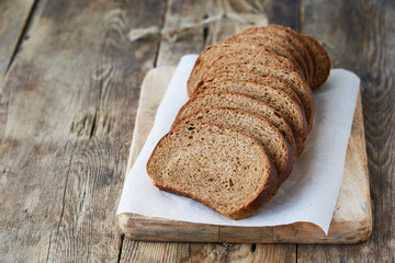 Slices of fresh rye bread on a wooden cutting board
