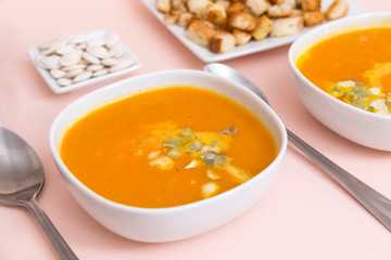 orange pumpkin soup in plates, spoons, vegetable soup