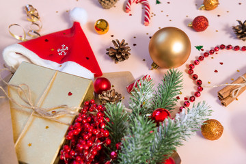 spruce branch, Santa hat, gift box, Golden and red Christmas balls, sweets, cones, branch with red berries, red beads, Christmas decor