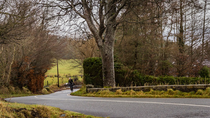 man rides road bicycle uphill