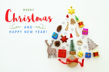 Top view image of festive decorations in shape of christmas tree over white wooden background. Flat lay.