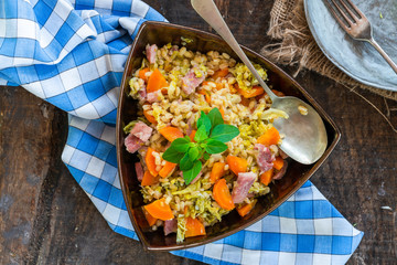 Pearl barley and bacon cassarole with carrots, leek and savoy cabbage - top view