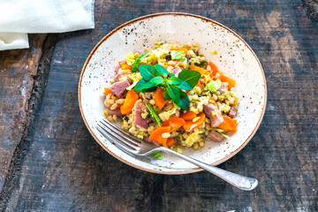 Pearl barley and bacon cassarole with carrots, leek and savoy cabbage - top view