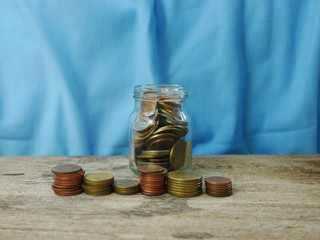 coins in jar on blue background