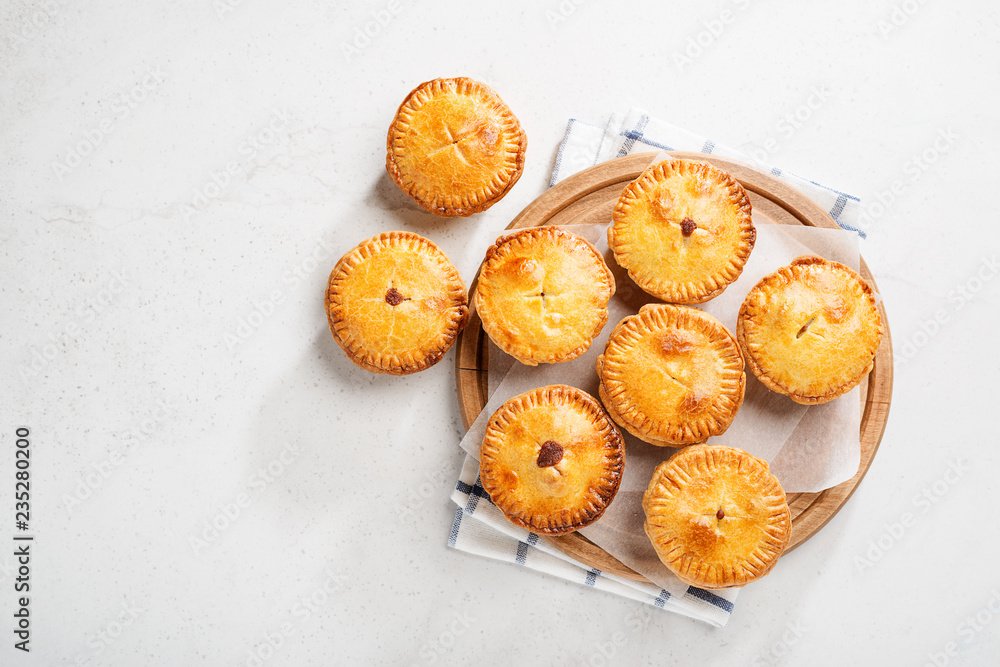 Wall mural traditional australian mini meat pies from shortbread dough on a light gray background.