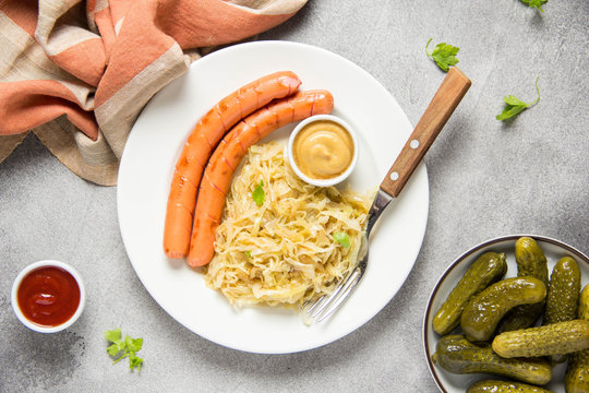 Braised white cabbage with two long fried sausages, mustard and pickled cucumbers. Classic German Hungarian Bavarian food