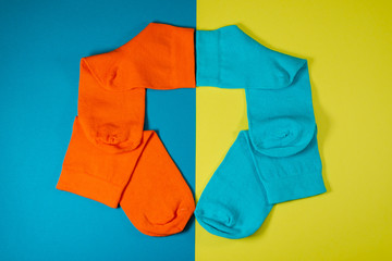 four new socks orange, blue on a yellow background