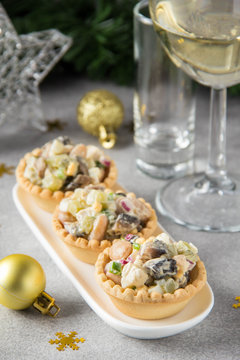 Russian salad with meat in tartlet. With potatoes, egg, cucumber, onion, mushrooms and mayonnaise. Olivier for new year table, Christmas appetizer
