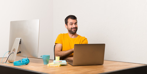Man working with laptot in a office presenting an idea while looking smiling towards