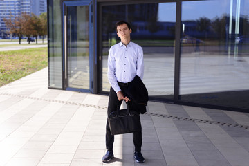 young businessman guy stands near building with large windows