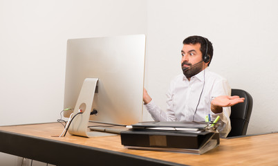 Telemarketer man in a office having doubts while raising hands and shoulders