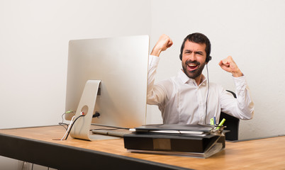 Telemarketer man in a office celebrating a victory in winner position