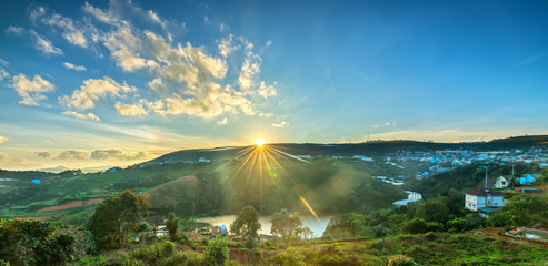 Dawn on plateau in morning with colorful sky, while sun rising from horizon shines down to small village landscape so beautiful idyllic countryside Dalat plateau, Vietnam