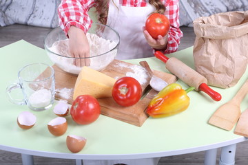 Children's hands are cooking pizza