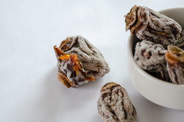 A bite persimmon on the white background.