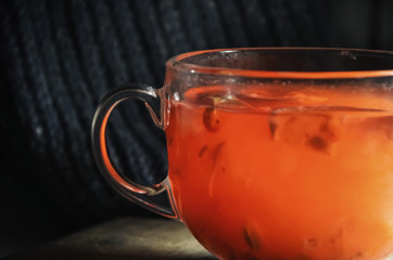 homemade red hot tea of viburnum with lemon and honey in a glass cup. close-up. warm fortified drink. concept of prevention and treatment of colds