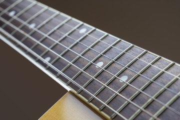 Neck acoustic guitar on a brown background