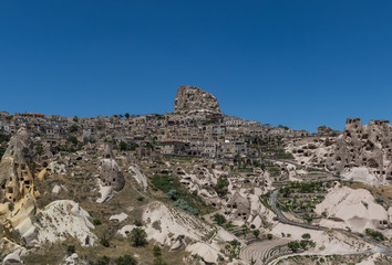 Fototapeta premium Uçhisar, Turkey - A Unesco World Heritage site, Cappadocia is famous for its fairy chimneys, churches and castles carved in the rock, and a unique heritage
