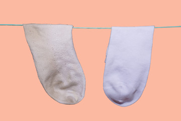 clean new white sock and next to the dirty old sock weighs