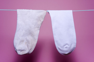 clean new white sock and next to the dirty old sock weighs