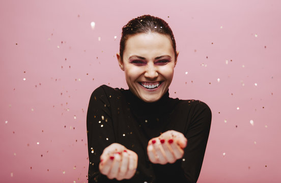 Beautiful young woman smiling with confetti