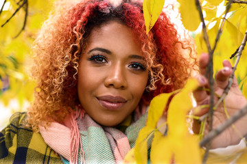Portrait of beautiful dark-skinned girl with red hair and golden lips.
