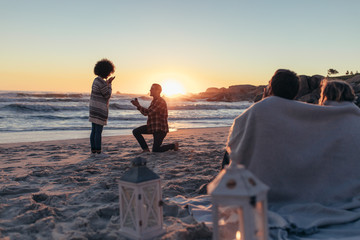 Marriage proposal at sunset beach - obrazy, fototapety, plakaty