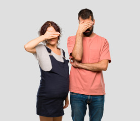 Couple with pregnant woman covering eyes by hands. Do not want to see something on isolated grey background