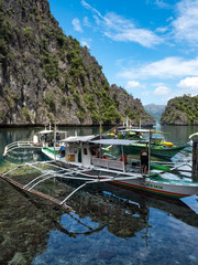 CORON, PHILIPPINES - November, 2018: Unidentified tourist and a traditional boats at the Barracuda...
